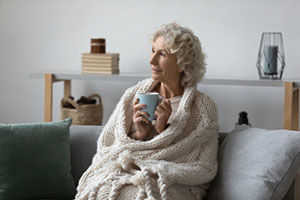 Woman Sitting on a Couch Drinking Tea